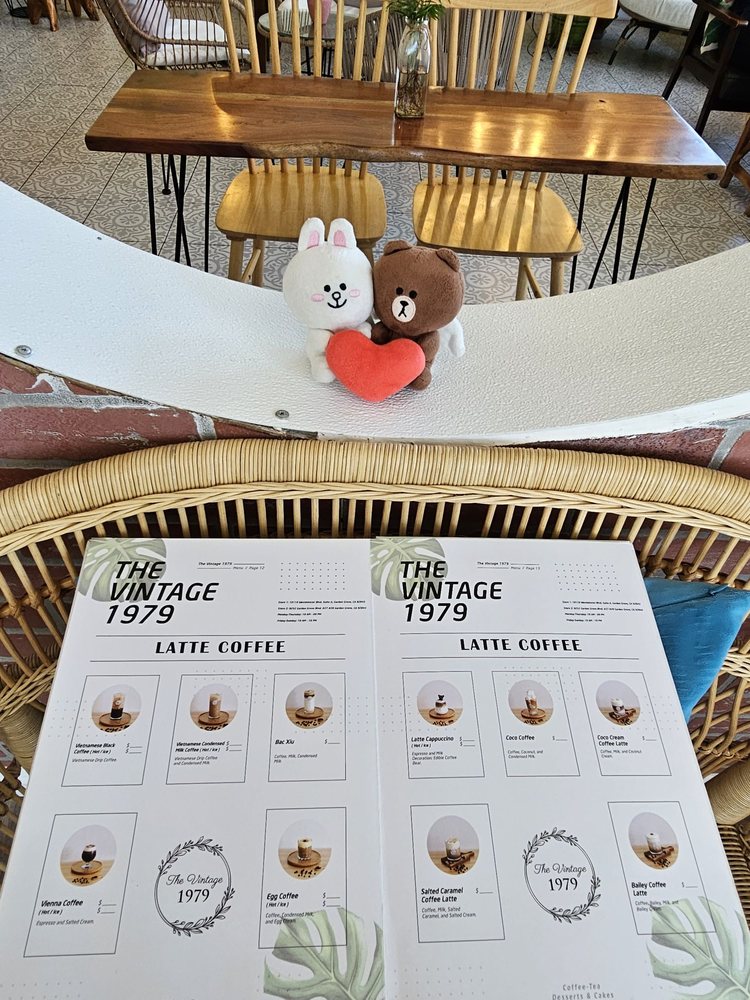 A plush bear tucked into a rattan chair beside the menu